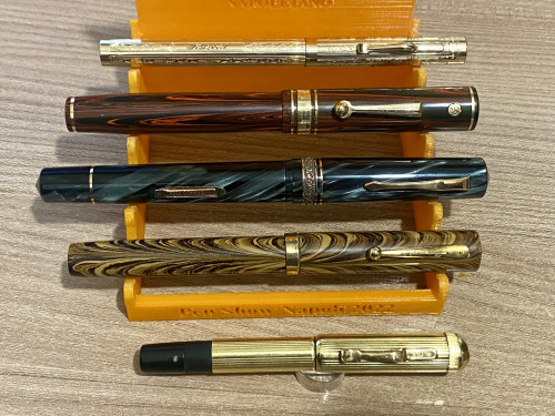 Dall’alto: Wahl All Metal Console, Wahl Decoband Rosewood, Leonardo Gioiellino in celluloide Mazucchelli, Waterman 94 Olive Ripple, Montblanc Safety #1 Corta in oro 18k.